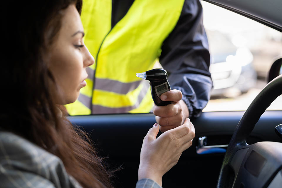 Policeman Doing Driver Alcohol Test Using Breathalyzer