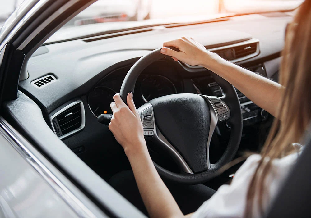 Unlicensed Driving hand on steering wheel lady