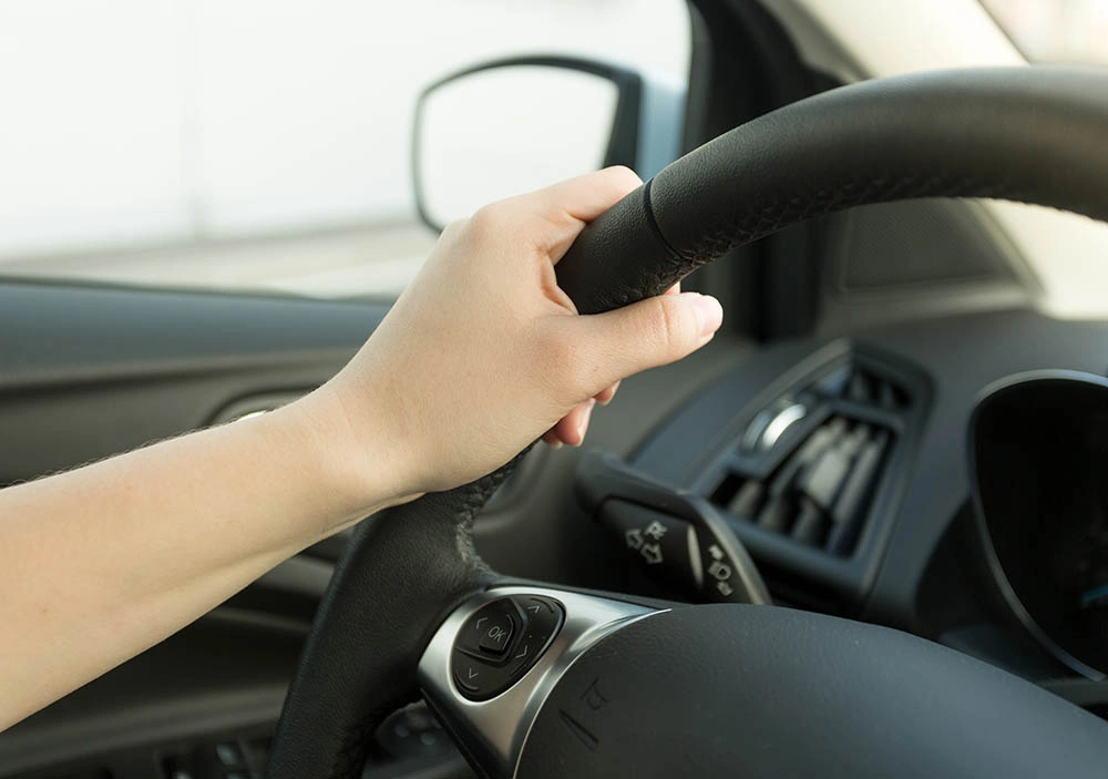 Unlicensed Driving hand on steering wheel